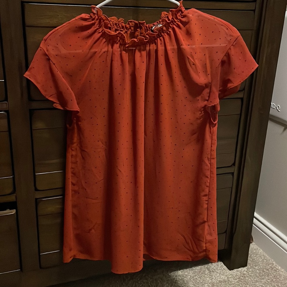 Short sleeve, burnt orange with black polka dots, neck is stretchy